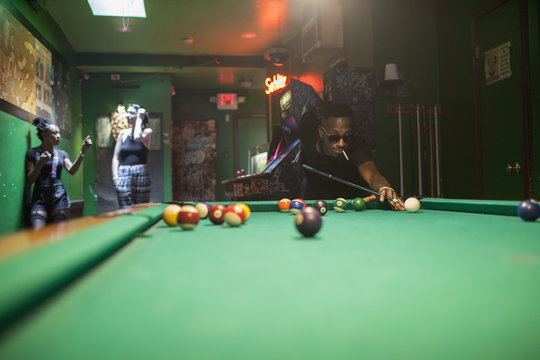A young man playing pool.