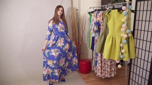 Charming model under the camera flashes presenting colored blue dress