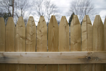 Close-Up of Wooden Stockade Privacy Fence with Picket Tops