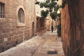 Obraz premium Man siluette walking on empty istreet n old town of Jerusalem. Jerusalem Old City. Israel