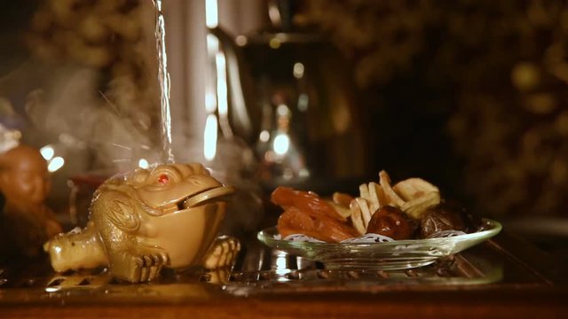 Tea figurine money toad changing color from water temperature.Slow motion