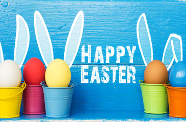 Easter eggs with Rabbit ears in colored buckets, selective focus image, Card Happy Easter 