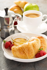Freshly baked croissants with honey and jam