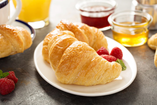 Freshly baked croissants with honey and jam