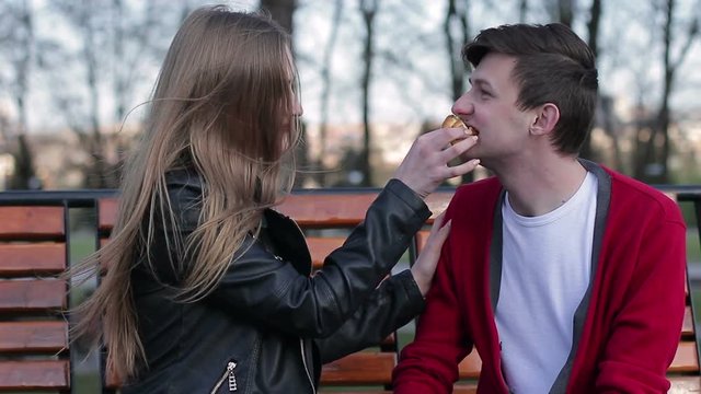 A young loving couple spends time. A girl is feeding a guy a cake