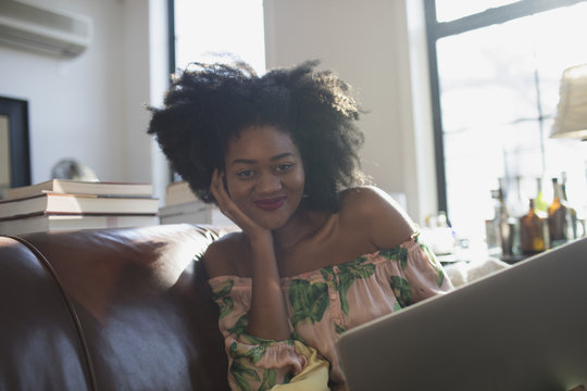 Portrait of smiling woman sitting on sofa at home