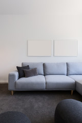 Vertical image of pastel blue sofa with blank artwork above