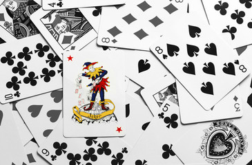 The Joker ontop Poker playing cards Mono Copyspace.