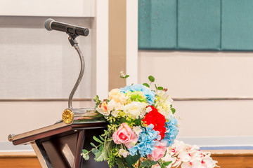 Microphone on podium with beautiful flowers.