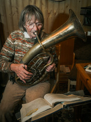 Senior woman is playing on a horn