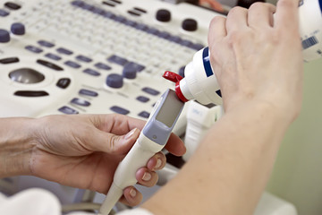 The doctor applies a gel for the ultrasound device to the sensor before starting the investigation, medical equipment, physician's hands