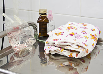 Saline, diaper, medical liquids on a gurney, medical instruments