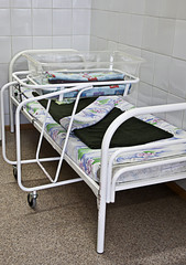 A newborn baby's hospital  and a hospital bed for a mother