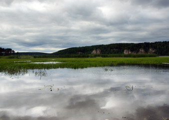 Sky reflected in the water of the river, landscape, swampy river bank