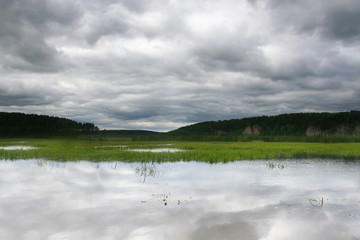 Sky reflected in the water of the river, landscape, swampy river bank