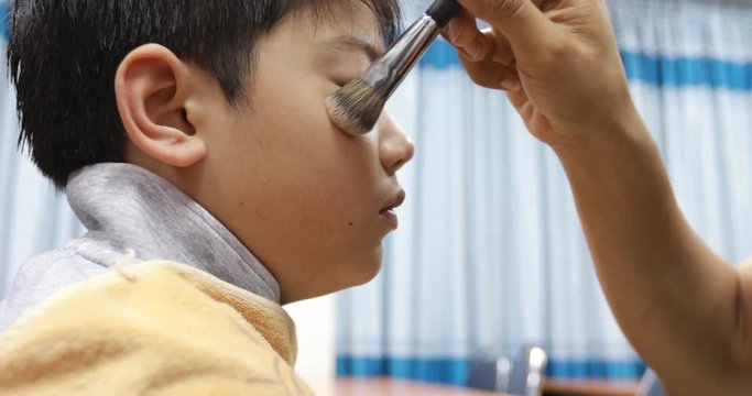 Make-up artist putting make-up on child model