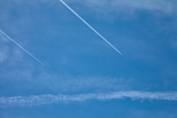 Airplanes flying in the blue sky among clouds and sunlight