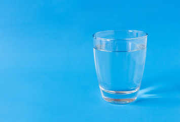 Water in glass on blue background
