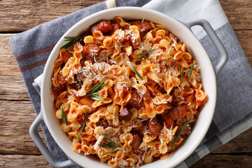 farfaline pasta with tomato, bacon and Parmesan close-up in a saucepan. horizontal top view