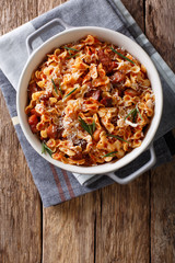 Baked pasta with tomato, bacon and cheese close-up. Vertical top view
