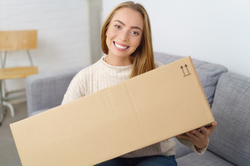 lachende frau freut sich über ein großes paket