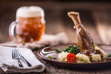 Lamb shank.Confit lamb shank with mashed potatoes spinach and draft beer in pup or restaurant.