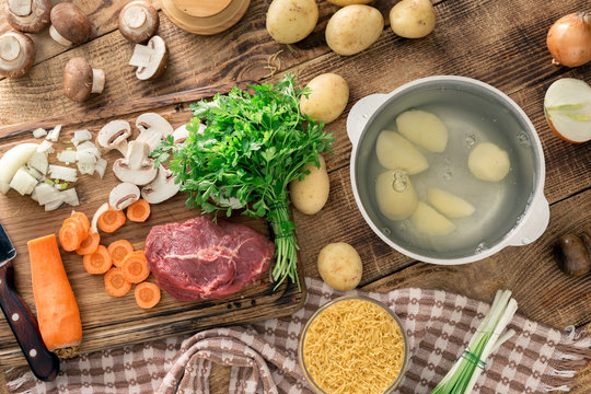 Ingredients for making soup on wooden table, top view