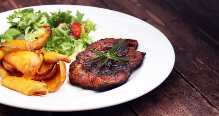 Grilled steaks, baked potatoes and salad