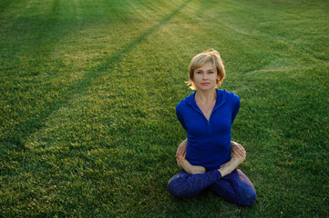 Fototapeta premium beautiful woman doing yoga exercises in park