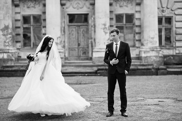 Wedding couple in love stay against old vintage palace.