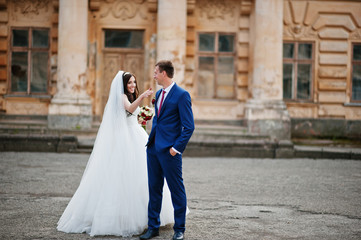 Wedding couple in love stay against old vintage palace.