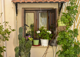 stone wall with wooden shutters on the window and flowers