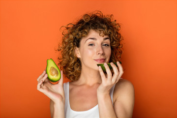 young curly woman with avocado