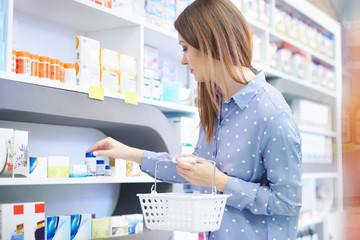 Customer exammining medicaments in drug store