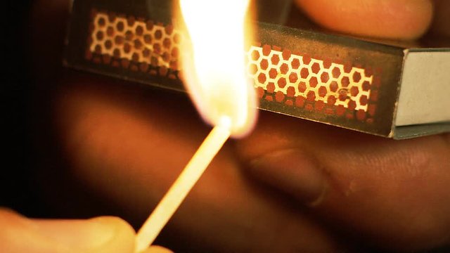 Close up of match being struck and lit, in slow motion