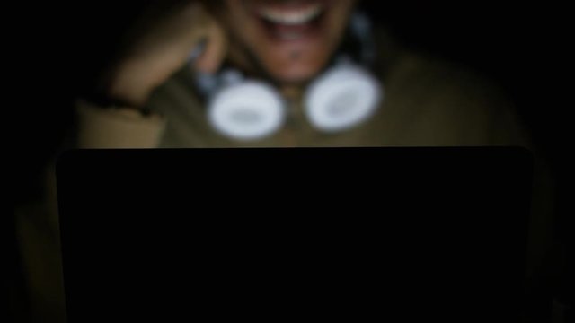 Blurred man talking on video call on his laptop before starting to undress, concept of sexting