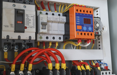 Close-up electrical wiring with fuses and contactors in control panel box of machine.