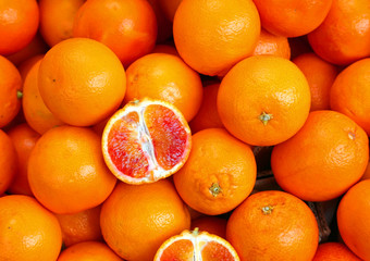 oranges and an orange cut in the stall of greengrocer