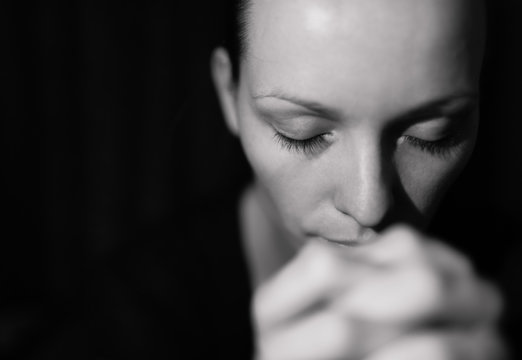 Portrait of woman praying and feeling desperate. 