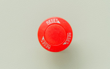 Red emergency stop and reset button on control panel for machine control.
