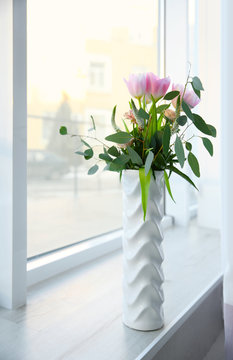 Vase with flowers on windowsill
