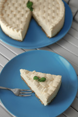 Piece of delicious cheesecake on blue plate