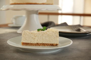 Piece of delicious cheesecake on grey table