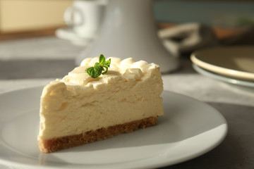 Piece of delicious cheesecake on grey table