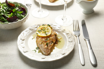 Plate with delicious chicken breast on table
