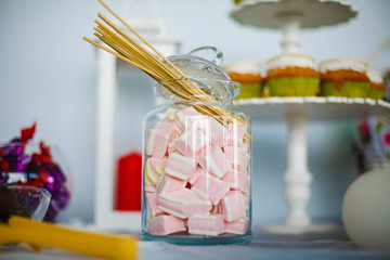 A delicious marshmallow in a jar on the table with other sweet desserts for a feast.