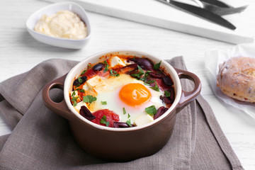 Baked egg in pot on wooden table