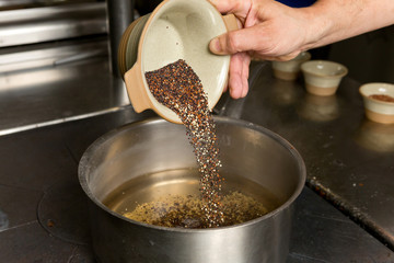 Organic quinoa grain being placed into a pan ready for cooking