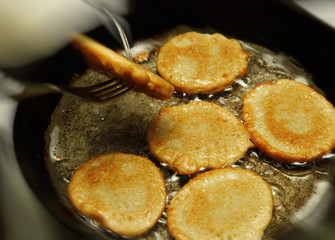 Cooking process of potato flapjacks on the pan with boiling sunflower oil close up with motion blur