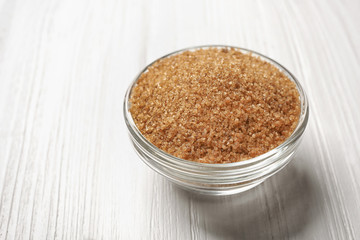 Brown sugar in bowl on wooden table